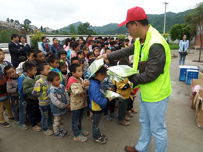 遵义草根助学会志愿者向受助学生发放T恤.jpg