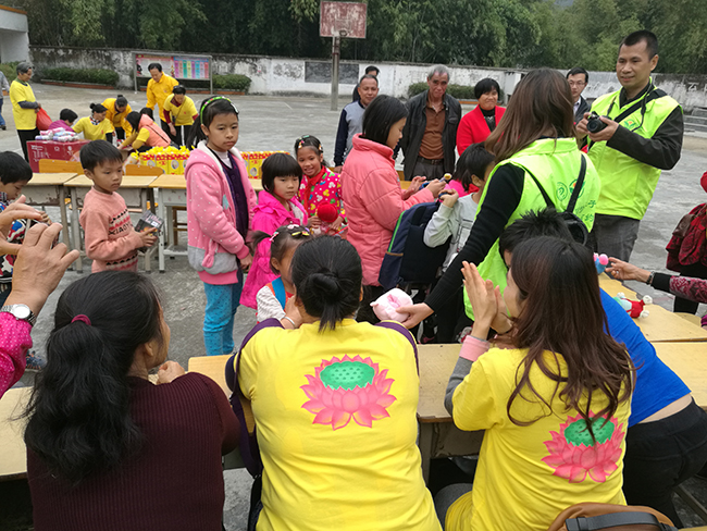和平谭兆小学留守儿童从志愿者手中领取奖品.jpg
