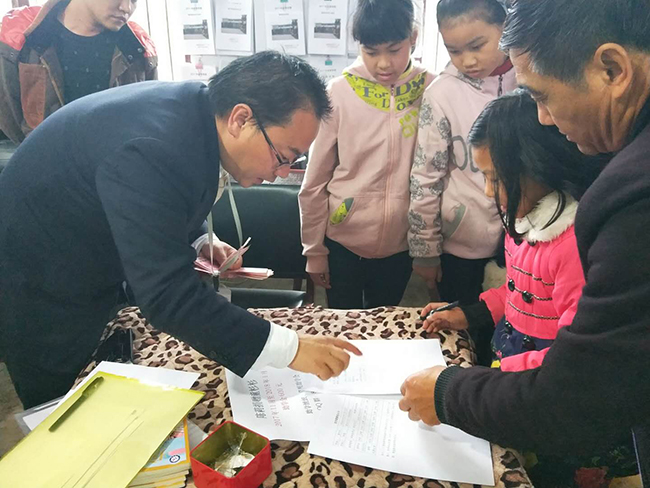 20171129草根助学会志愿者指导受助学生签收助学金.jpg