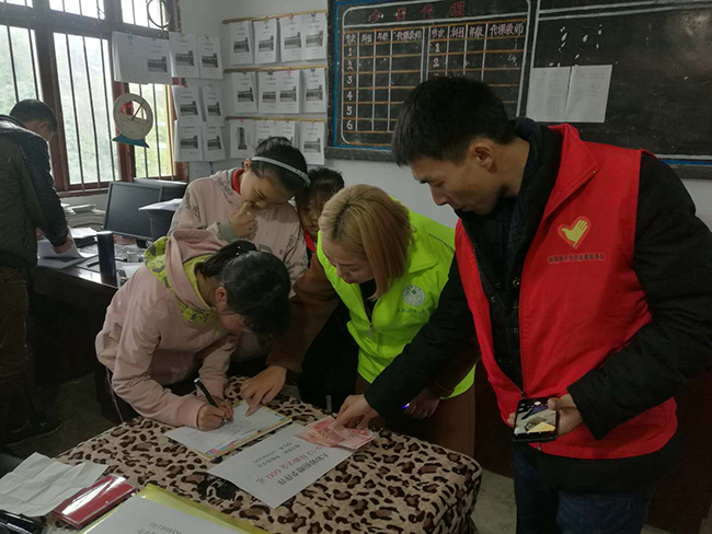 20171129志愿者杨俊指导李萍萍签收助学金.jpg